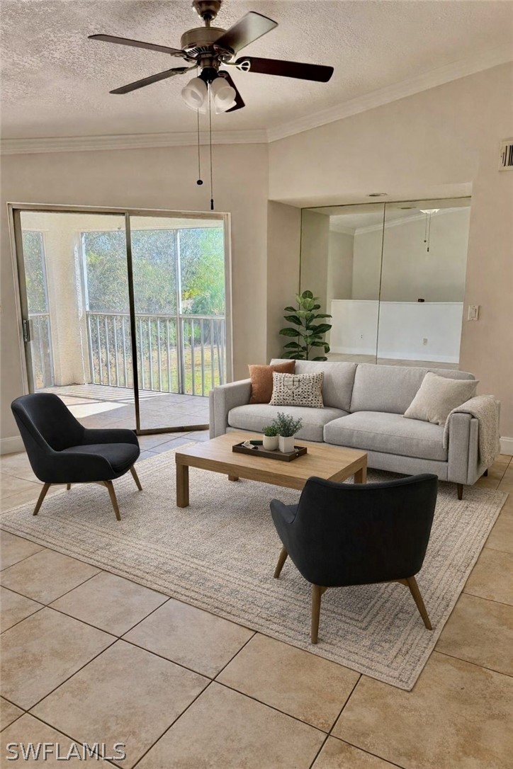 Living room featuring a ceiling fan, light tile .