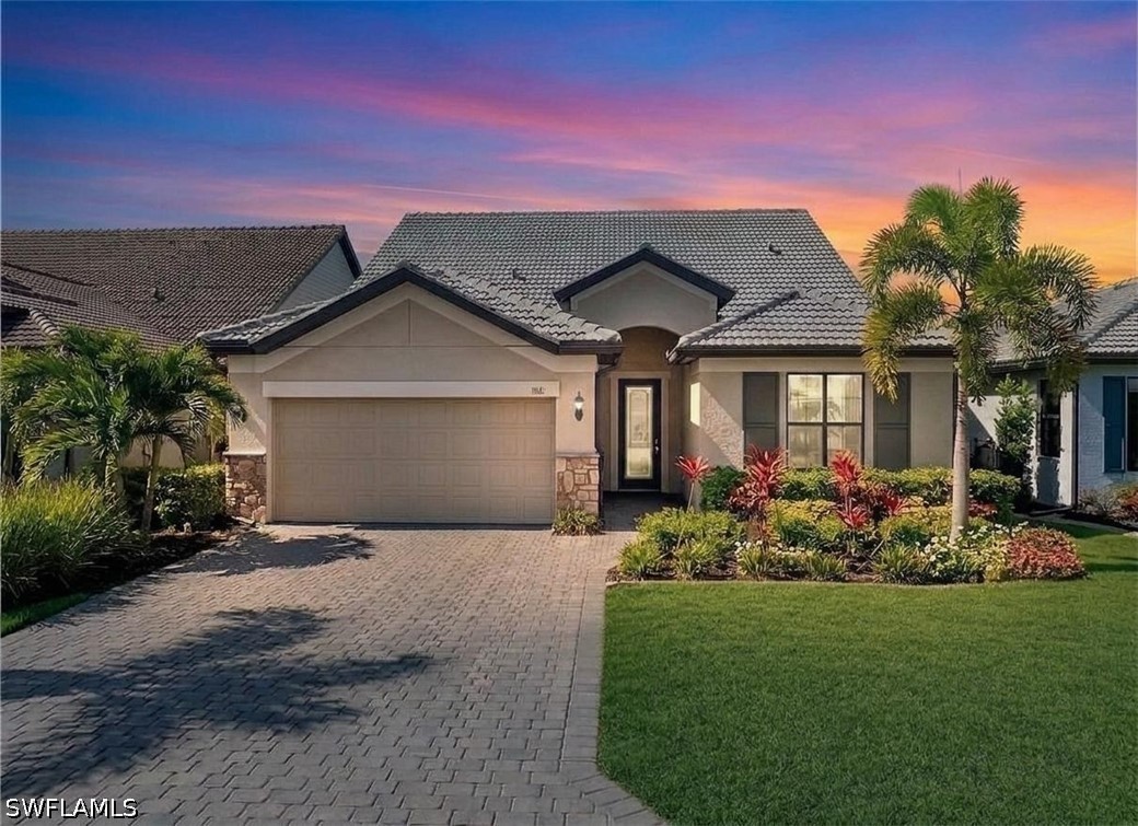 2 story home featuring stone siding, stucco siding