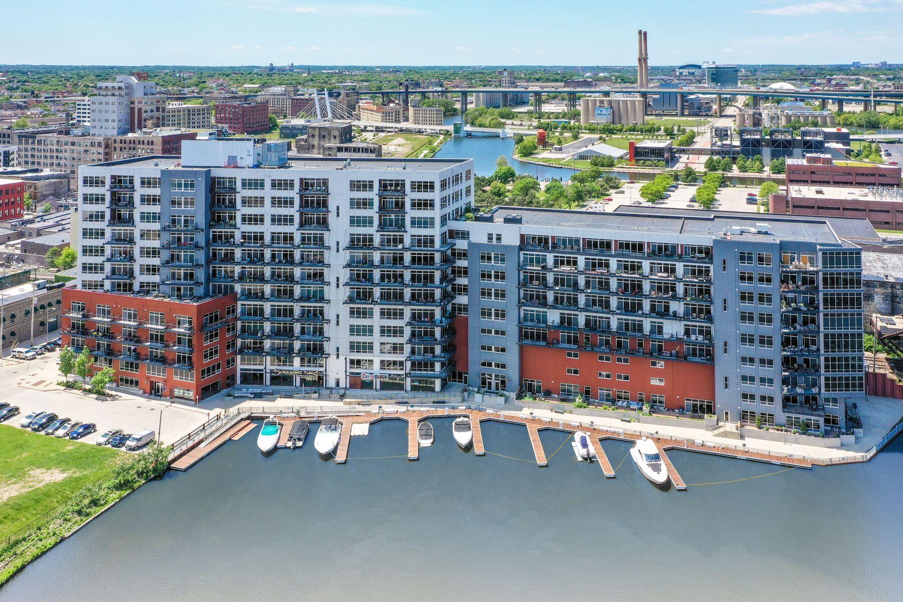 Downtown Milwaukee condominium beside the river, with marina boats and bridges in the distance.