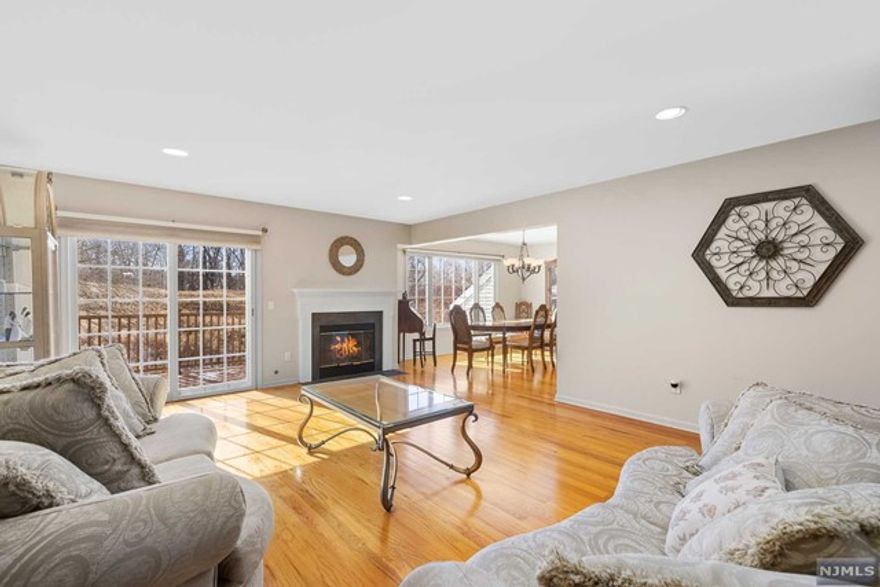 Eat-in kitchen w/ tall custom cabinetry, ample granite countertops and center island. A glorious family room w high ceilings, gleaming hard wood floors & wood- burning fireplace. Sliding glass doors open to a deck overlooking parkland. Office or reading room adjacent to the family room, powder room & laundry room all located on the first floor. On the second floor, a grand master suite with cedar floors closets and bonus walk-in closet, master suite bathrooms has an abundance of natural light from its two new skylights, jacuzzi tub and separate shower. A generously sized second bedroom has double cedar floor closets, entrance to walk- in attic and access to full bathroom. A cozy third bedroom with ample closets and storage space. A vast finished basement with kitchenette, bathroom, gas fire place, utility room, extra storage rooms and walk-out access provides an additional guest quarters or entertaining space. New roof, newer air conditioner & furnace.