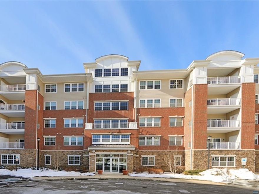 Welcome to this sophisticated Colfax model condo in Wanaque Reserve, a 55 plus active adult community. This 2 bedroom,2 bath condo has been decorated with custom design features throughout the home including custom painted hardwood floors. The living room has a dual sliding door bringing the outdoors in by opening up to your private covered balcony with fountain views. The den has crown molding accents, a custom built-in entertainment unit & features French doors & a transom window providing style and privacy. The kitchen has been tastefully decorated with granite counter tops, stainless-steel appliances and a stylish banquette for casual dining. Enjoy elegant dining in the dining room which boasts crown molding, recessed lighting and 2 chandeliers. The primary suite has been professionally painted, wall papered and has a tray ceiling creating a luxurious paradise. Enjoy all the community has to offer indoor & outdoor swimming, fitness center, tennis, clubs & more.