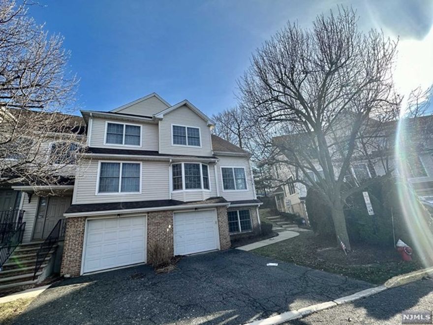 Freshly painted, polished and cleaned. Parking space and garage, sunny corner unit with two large bedrooms and two full baths on top level, closets galore. First floor consists of a large living room and fireplace, dining room, cooking kitchen with counter and seating area, den and half bath. Ground level consists of a play room, bedroom, storage and garage. Washer and dryer hookups on top floor by main bedroom.