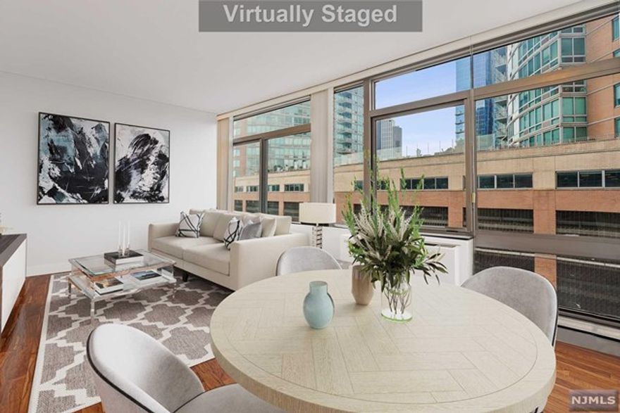 Enjoy a spacious corner property with NYC views in a serene top floor setting at Liberty Terrace. This amazing 1 bed/1 bath Condo nestled on the waterfront in Paulus Hook has 922 sqft of living space, oversized windows exposing north, and east exposures. Condo features hardwood floors throughout, kitchen with granite countertops, stainless steel appliances, and in-unit washer / dryer. Spacious marble bathroom has a heated floor, soaking tub and separate shower. Prime location has Essex St Lightrail, Paulus Hook Ferry and Exchange Path minutes away. Near Hudson River Waterfront Walkway, J. Owen Grundy Park, and Liberty Park. Building has 24hr concierge, and private gym. Maintenance includes heat, water, hot and water. Unit has one parking.