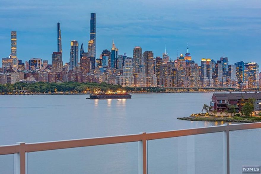 Discover the waterfront luxury in this chic urban sanctuary, where the living room's open-plan design frames the Manhattan skyline through expansive windows, casting natural light across warm wooden floors and a sophisticated white sectional. Dine beneath an artistic chandelier at the sleek glass-top table, encircled by white leather chairs. The kitchen, a masterpiece of design, boasts Caesarstone countertops and top-tier Subzero, Wolf, and Bosch appliances, complemented by a custom wine bar. Unwind in the spa-like bathroom with its marble-encased soaking tub and double vanity. Step outside to a private deck with rust-resistant flooring, offering a front-row seat to breathtaking views. This residence is a curated blend of comfort, elegance, and unparalleled style, designed for the discerning.