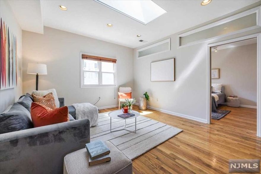 Discover the perfect bright urban retreat in this sunny 3-bedroom, 2-bathroom condo in the heart of downtown Hoboken. This top-floor gem boasts a loft-like ambiance with high ceilings, skylights throughout, a spacious kitchen, and a generous dining room. The split-level layout offers the feel of a house, featuring two oversized bedrooms, each with its bathroom and ample closet space. Ideal for families, professionals, or anyone seeking extra space for guests or a home office, this residence also includes a sizable city facing outdoor roof deck, perfect for entertaining including watching movies with friends. Additional highlights include a washer/dryer, central air, and beautiful hardwood flooring throughout. The property comes complete with 1-car garage parking, low maintenance fees, and a large storage area under the house. Conveniently located just minutes from the PATH and Ferry to NYC, this home provides easy access to all of Hoboken's amenities, including the vibrant Washing