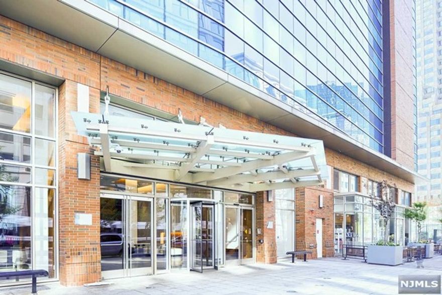 In Jersey City's Premier Luxury Waterfront Building, 77 Hudson! Glass walls of floor-to-ceiling windows floods your home with natural sunlight and breathtaking views of NYC & the Hudson River. An open European style kitchen with top-of-the-line finishes opens into the living room and dining area, the perfect space for entertaining. Custom upgrades include the addition of recessed lights in the living room, custom window treatment, custom closets for additional storage and a NEST thermostat. Central air, in-unit washer/dryer and hardwood floors throughout. Over 44,000 SQFT of resort-like amenities include: state-of-the-art fitness center, yoga/Pilates room, pool, barbecue area, jacuzzi, sauna, steam room, virtual golf, game room, playroom, multiple resident lounges, screening room, conference room, plus much more! Around the corner from all major public transportation (PATH, light rail, ferry), restaurants and shops. Gourmet supermarket & coffee shop at the base of the building.