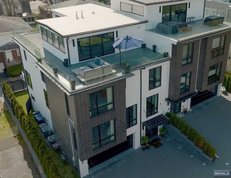 Minimalistic modern home. Superbly designed, has a "SOHO Hotel" feel. Fantastic 180 degree views > GW bridge to Midtown. Up high on the hill on a double size lot which allowing wider interior living space. Large windows and glass doors allowing more natural sunlight. Full southern exposure, 3 levels of outdoor spaces. Sleek European kitchen, large island w/an advanced overhead hood = vents outside, Italian cabinets, Wolf appls, full size sub zero fridge and freezer, wine fridge, 3 FPL, and a S. facing deck. Too many extras to list, such as a hydraulic elevator, 6 zone radiant heat floors (incl. garage), 3zone AC, 4 zone built-in speaker sys w/outdoor speaker on roof deck. High ceilings throughout, a glass walled office, glass railings in & out, Stunning Master bath w/body spray steam shower, white oak floors, water filtration system in entire home. Your Glamour home awaits.