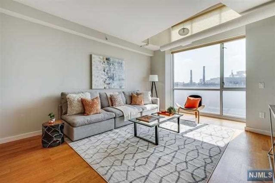 Welcome to urban luxury living in Downtown Jersey City's Village section! This remarkable south-facing penthouse condo offers an abundance of natural light streaming through its floor-to-ceiling windows. Located in a modern elevator building, this 2-bedroom, 2-bathroom is your dream home! As you step inside, you'll be greeted by an inviting open floor plan that seamlessly connects the living, dining, and kitchen areas. Hardwood floors flow throughout, and the unit has the added bonus of custom Energy Efficient Hunter Douglas Honeycomb blinds. The heart of this home is the chef's dream kitchen, fully equipped with top-of-the-line stainless steel appliances, quartz countertops, and custom cabinetry. The designated formal dining area is perfect for hosting intimate dinners for entertaining friends and family. The primary bedroom offers ample space to accommodate a king-size bed. It features an updated ensuite bathroom with modern fixtures and finishes.