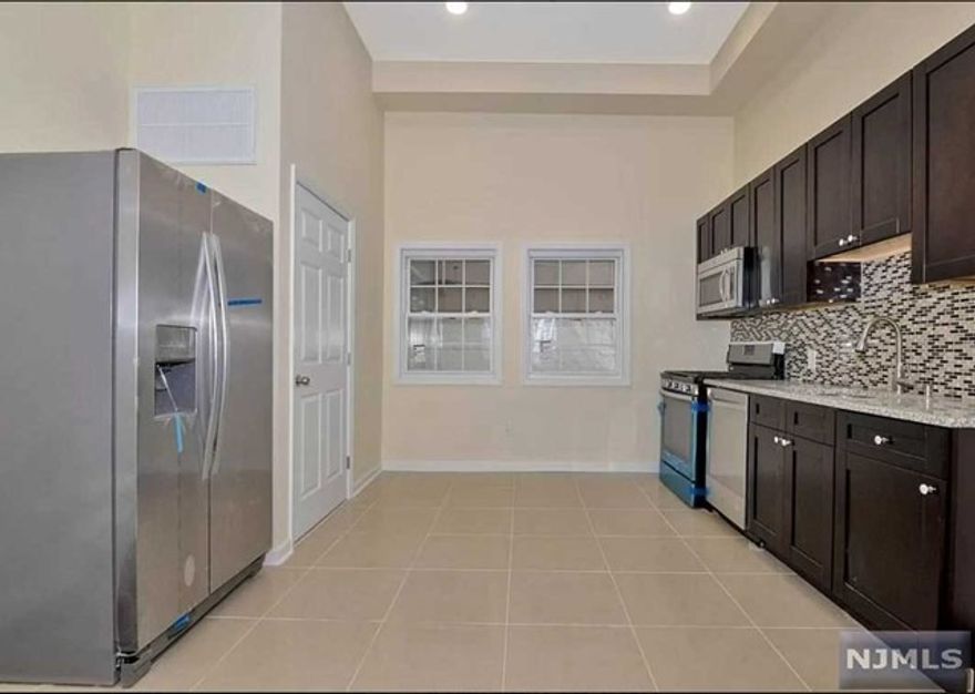 Beautifully renovated large one bedroom apartment in a fully renovated 4 family building. This apartment has an open layout with very high ceilings, central A/C, hardwood floors, tile in kitchen and bathroom. Private fenced in patio, recessed lighting, granite countertops, stainless built in microwave, dishwasher and refrigerator. Four closets. Across from large park. Close to restaurants and shopping. Bus stop 200 ft from the door. None smoking building. One month brokers fee, $40 NTN credit check . Owner is a licensed RE agent.