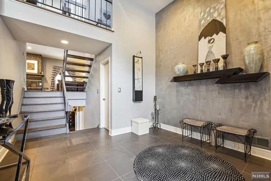 Welcome Home to this EXQUISITE 3bd townhouse in desirable Stepping Ridge - North Caldwell. When you enter this home, you are greeted by a grand foyer with custom tile, extended size closet and the inviting open floor plan with gleaming hardwood floors throughout. The sun filled living room with a gorgeous wainscoting wall and custom bar unit are accented by a gas-burning fireplace which makes this the perfect space for entertaining or relaxing. Sliding glass doors lead to a private deck where you can grill. The large eat-in kitchen has granite countertops , new stainless steel appliances, plenty of custom cabinetry for storage and a separate spacious breakfast area with large windows. An open staircase leads to a cozy nook for reading and a mezzanine level overlooking the grand foyer. The second level features a very spacious primary bedroom with custom painting, cathedral ceiling, large walk-in closet, private dressing area and relax in primary renovated bath with a stall shower