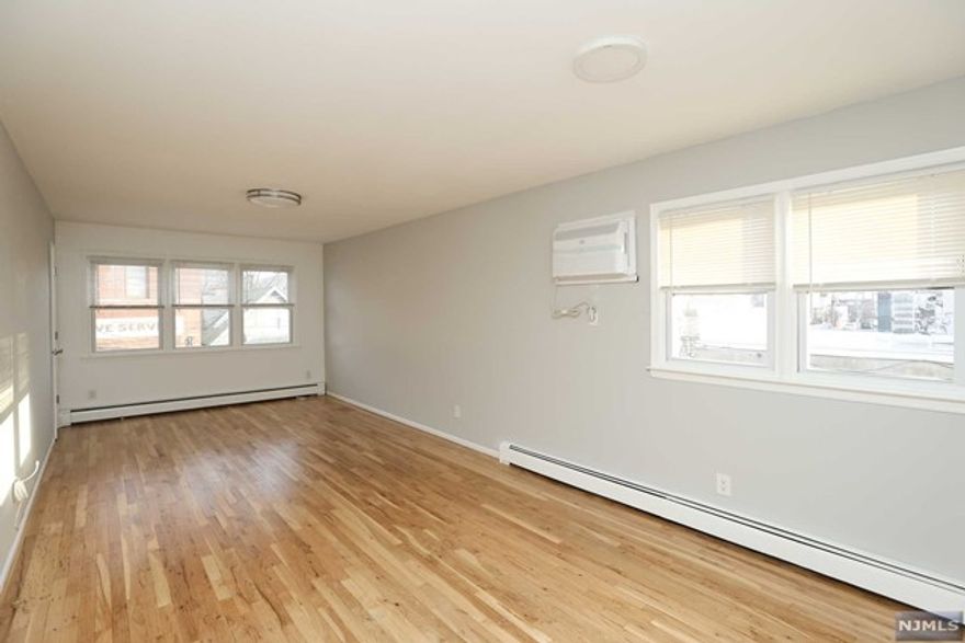 Spacious,sunny + bright 2 BR/1 bath apartment. FRESHLY PAINTED & NEWLY REFINISHED HARDWOOD FLOORS. Kitchen w/NEW refrigerator + stove. Lg.living room/dining area. Small addtl room perfect for home office. Washer/Dryer ground fl. Gas Heat/Hot water included. Tenant pays electric, cable, cooking gas. 2 minute walk to NYC Bus stop (approx 30 min to Port Authority) Street parking. Close to shopping and restaurants. Sorry no pets. Rental Insurance required.