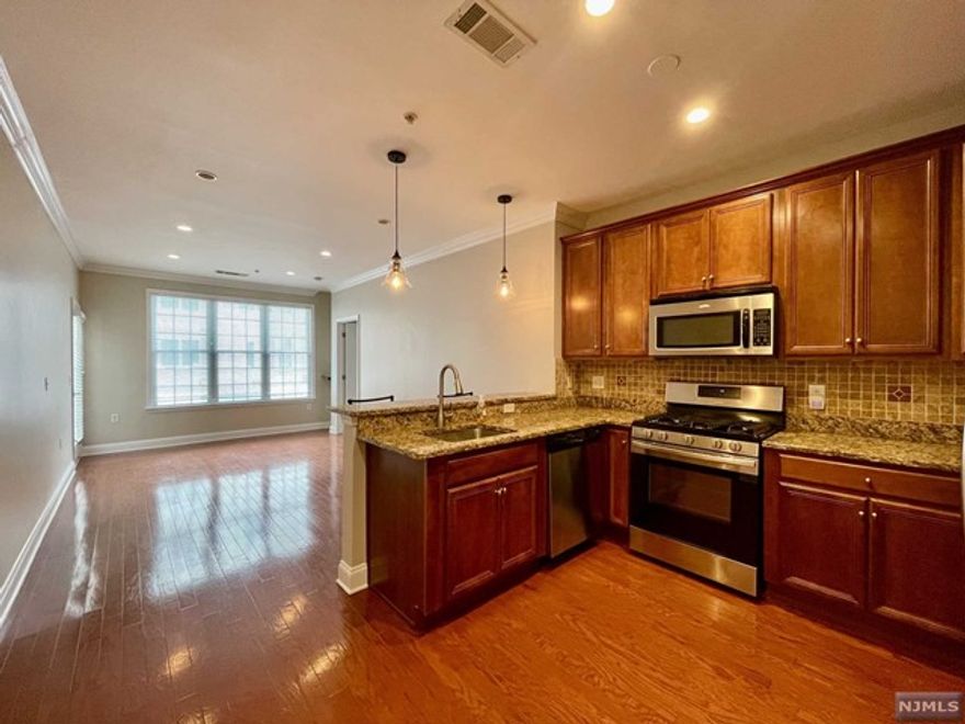 LIVE THE GRANDE LIFE! Freshly painted, magnificent first floor condo, boasting 2 bedrooms and 2 full baths with direct access to the courtyard, providing a seamless blend of indoor and outdoor living. Featuring a nice size living/dining combo with doorway to the courtyard & patio. The primary bedroom with a large WIC is a serene retreat, featuring sliders that also open up to the courtyard and patio. The kitchen has plenty of cabinets and counter space, breakfast bar, granite counters & SS appliances. Additionally, this condo features the elegant touch of laminate wood flooring. In unit laundry makes chores a breeze. Great location in building 1 which is directly next to the clubhouse & amenities. Low taxes only $5747. 1 Car assigned parking space in garage with elevator access and add'l parking outside of building. Enjoy all the amenities the Grande has to offer, 2 swimming pools, 2 club houses, billiards rooms, tennis courts, fitness centers, conference rooms, party rooms.