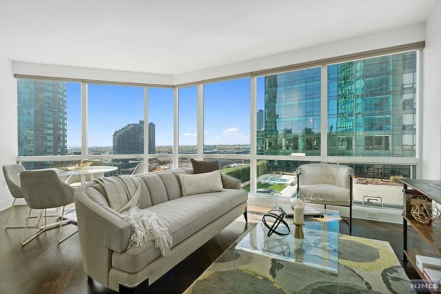 Contemporary, generous in size, and close to everything, this fantastic Jersey City condo offers the vibrant lifestyle you've always dreamed of! Enviably located in the highly coveted 77 Hudson building, this meticulously maintained 2-bedroom, 2-bath residence is ready for you to move in and enjoy. From the grand lobby, take the elevator to explore your south-facing unit that commands panoramic views of the Hudson River, New York Harbor, and the Statue of Liberty. Sure to delight the avid cook, the modern European kitchen displays a host of stainless steel appliances, white lacquer cabinetry with under-cabinet trim lighting, a pantry, and Carrara marble countertops. Wake up refreshed in the comforts of your well-proportioned private retreats, all graced with ample storage space. Your versatile second bedroom can be converted into a media room or home office. Other noteworthy features are an in-unit washer/dryer, tons of storage closets, and 1 deeded parking spot.