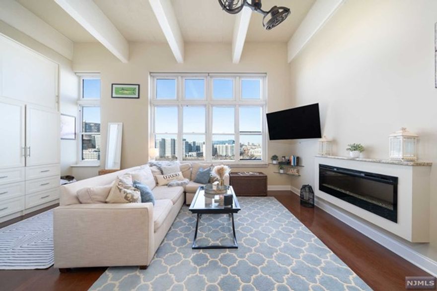 Experience the essence of Uptown Hoboken living at Hudson Tea Building. Wake up to breathtaking NYC & Hudson River vistas daily. Revel in the kitchen's natural wood shaker cabinets, stainless appliances, stone countertops & breakfast bar. With 14 ft ceilings, expansive windows, & exposed industrial concrete beams, this condo exudes openness & character. Enjoy a renovated bath with glass enclosed walk-in shower, new vanity, tile flooring, overhead lighting & fans. Custom closets & extra storage space add convenience. Rental parking available at LAZ garage across the street. Hudson Tea amenities include 24-hour concierge, fitness center, residents lounge, business center & kids playroom. Access free shuttle to PATH, dry cleaner & Choc O Pain French cafe onsite. Located on Uptown Hudson River waterfront, endless shopping & dining options await. Direct 14th St Ferry to Midtown & WFC just a short walk away.