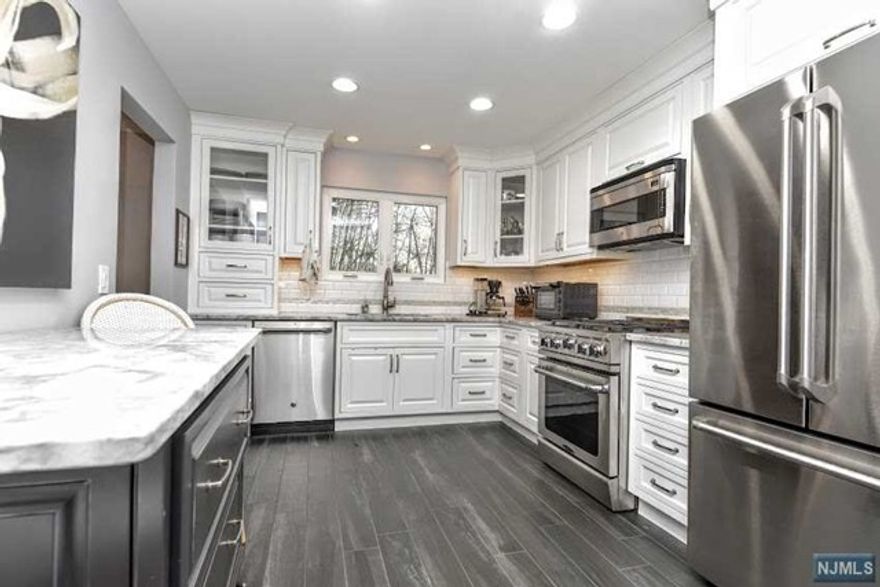 Welcome to Langdale Townhomes with its top location on a quiet cul-de-sac. This end unit 2 bedroom, 2.5 bath townhouse is surrounded by woods. The townhouse has been completely renovated. The interior boasts a spectacular updated kitchen with granite countertops and top of the line stainless steel appliances. Walk into a large foyer with half bath that has access to the garage. The first floor features the main living area with a large living room with a large glass fireplace and dining room with doors leading to a deck overlooking the woods. The chef's kitchen boasts state of the art appliances and is fully updated. The second floor features a large family room with an enormous walk in closet. Up a few steps to a large master bedroom, walk in closet and a primary bathroom. Here you will also find the second bedroom along with a completely renovated second bathroom. The home features central air conditioning, a garage with electric door openers and gas fireplace.