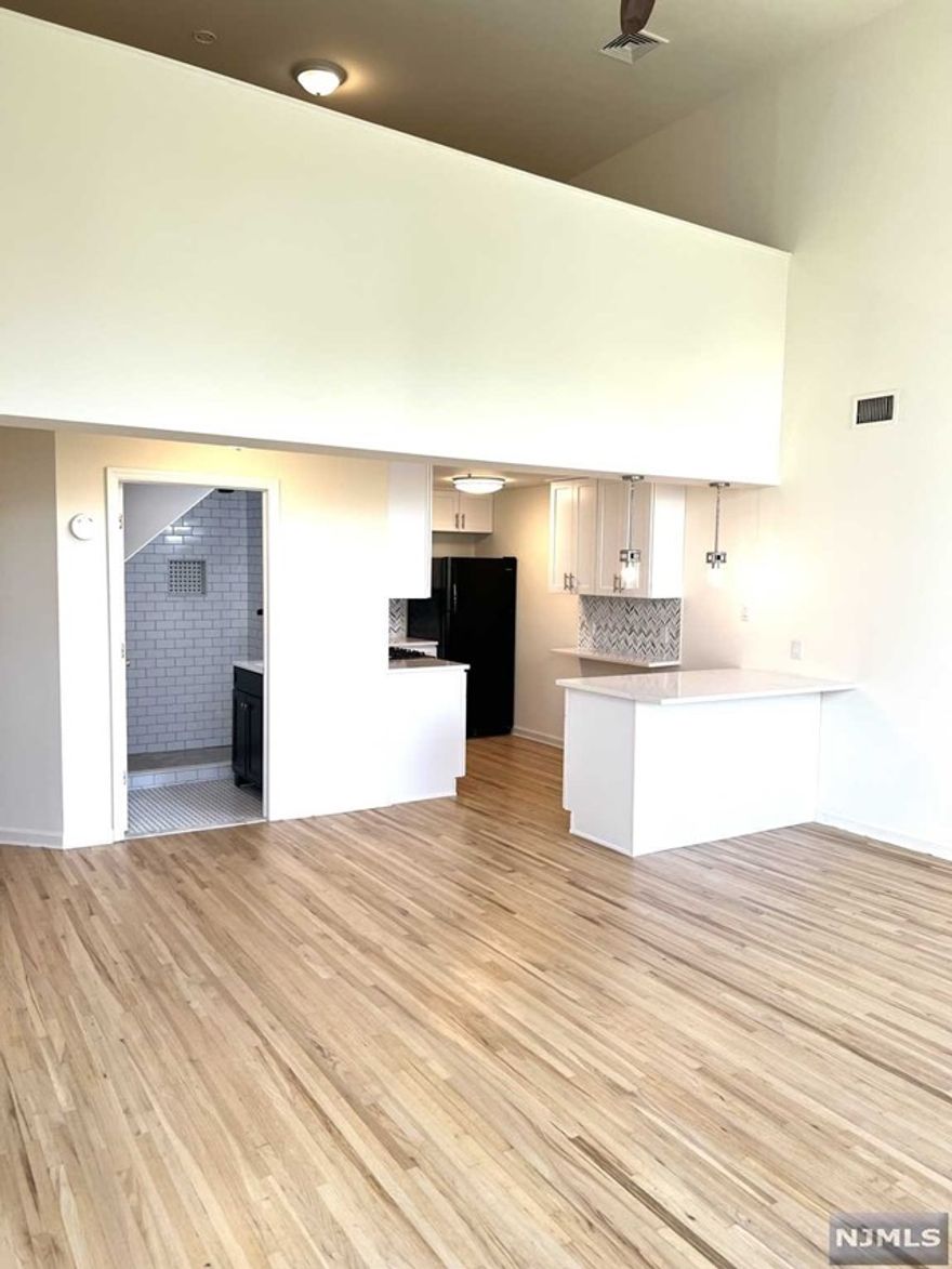 Renovated loft style 2 bedroom apartment with 2 floors of living space, central air, and 18 ft ceilings. The first floor features an open concept layout with a brand new eat in kitchen with quartz countertops, stainless steel appliances, and a large island. There is also a large bedroom, a bathroom, and storage closet. The second floor offers a second bedroom over looking the main living area. The building offers coin-operated laundry on premises. This building is ideally located in the heart of downtown Rutherford with shops, restaurants, and bars all near by. This is an ideal location if you are commuting with public transportation. The Rutherford train station is directly across the street and the bus stop for NJ transit bus 190 and 76 are at your door step. There is a parking space available for an additional $100/month if needed.