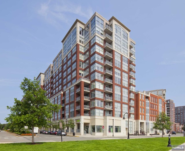 Welcome home to this rare 1,622sqft 2 bed + den boasting an open layout, direct skyline views from each room in addition to your private terrace. The luxury condo features gleaming hardwood floors, oversized windows with Hunter Douglas blinds, central air, in-unit washer/dryer and one deeded parking spot. The fully upgraded open-style chef's kitchen feat. SS appliances with granite counter tops and custom cabinets overlooking the living and dining area; perfect for entertaining. The spacious master bedroom includes a spa-like ensuite and custom closets in every bedroom. The second bedroom is sizeable and the den can be used as an office or nursery. The luxury community offers 24/7 concierge service, theater room, yoga room, gyms, 2 outdoor pools, jacuzzi, newly renovated community rooms, shops on premises and shuttle service to and from the PATH. Conveniently located near NYC Ferry, bus stop, and all the uptown Hoboken has to offer.