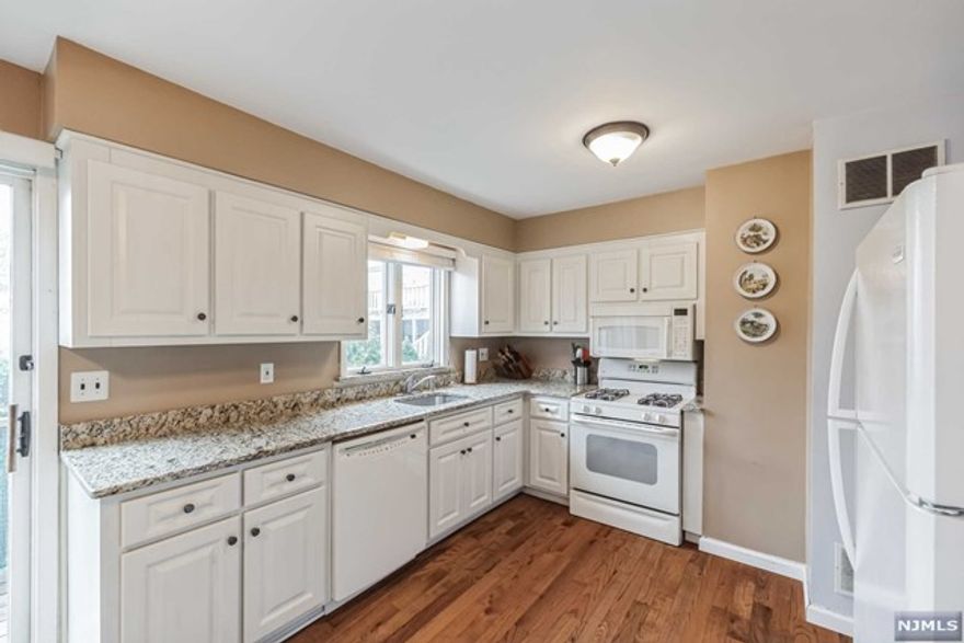 Welcome to this hidden gem in Village Oak - a 3-level, 2-bedroom condo featuring 2 full and 2 half bathrooms. Nestled away from the main road, the residence offers a tranquil setting and still allows convenient access to major highways, shopping centers, parks, restaurants, and NY transportation links. The ground floor boasts an attached garage, a family room with sliders leading to a quiet patio, laundry, and a convenient 1/2 bath. The updated eat-in kitchen showcases gleaming granite countertops and a pass-through to the dining room. A set of sliders off the kitchen leads to a charming balcony. The spacious living room and an additional powder room complete the main level, bathed in natural light thanks to its east/west exposure. Oak hardwood flooring graces the main level, adding warmth and character to the home. The upper level features a generous master bedroom with an ensuite master bath, an oversized second bedroom, and a second full bath offering ample space and privacy.