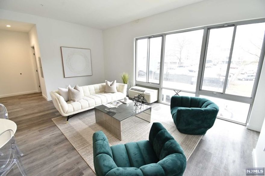 This new spacious 2BR apartment affords a comfortable living space with luxury vinyl flooring. Kitchen with SS Frigidaire appliances, microwave, dishwasher, gas stove/oven, and fridge. Featuring hard wood cabinets and beautiful granite countertops, breakfast bar for casual dining. The bathrooms boast elegant porcelain tile, MBR has generous sized standup shower, and 2nd bath a soothing tub shower. The apartment offers wall PTAC heating and cooling units, ample closet space. 10-12 foot high ceilings, giving it an airy, spacious feel. The building has a washer and dryer for all your laundry needs. It also offers 1 parking space included, a modern exercise room for fitness enthusiasts and storage lockers for extra space. One of the many advantages of this apartment is its prime location, which is in close proximity to both the train and bus station, making commuting a breeze. The rent includes heat and hot water. It's an ideal space for those seeking comfort and modern living.