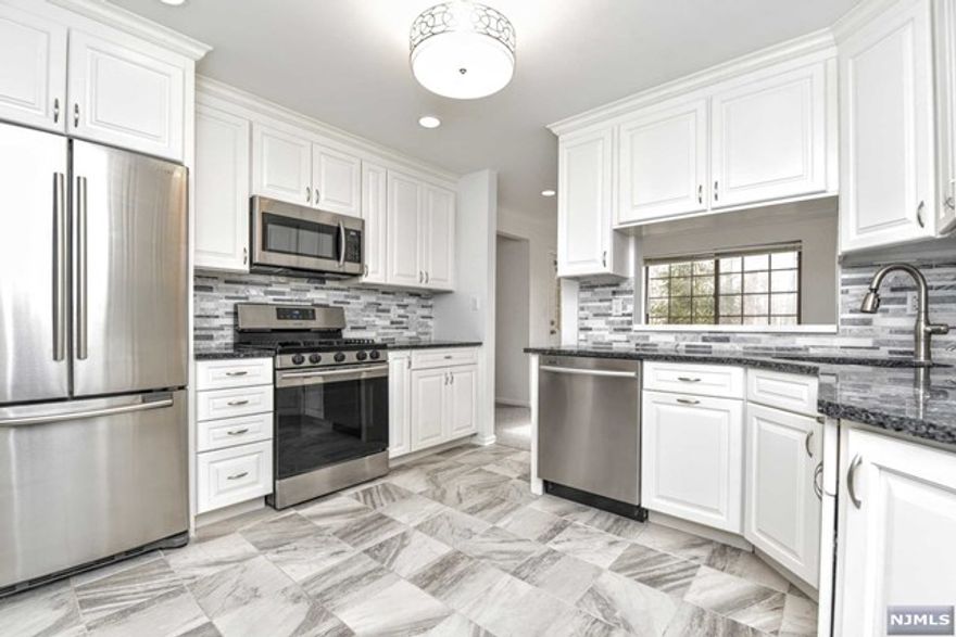 MOVE RIGHT IN! FIRST FLOOR! Beautifully renovated 2 bedrooms /2 baths, one car garage and storage unit in desirable Ridge Gardens. Freshly painted, brand new carpeting, recessed lighting, new water heater. Modern kitchen with ample soft close white cabinetry, granite counters, pantry, tile backsplash and newer stainless steel appliances. Sun-drenched large living and dining area for entertaining. Relax on the quiet deck overlooking peaceful woods. Spacious primary bedroom fit for a king size bed, huge walk-in closet and updated en-suite with large stall shower. Second bedroom has double door entry & closet. Updated full hall bath with shower over tub. Laundry area in unit. Garage and storage unit are in same building on the same level conveniently located close to front door-no steps. Amenities include pool, tennis and community room. Quick access to major highways, nearby NYC transit, shopping & restaurants.