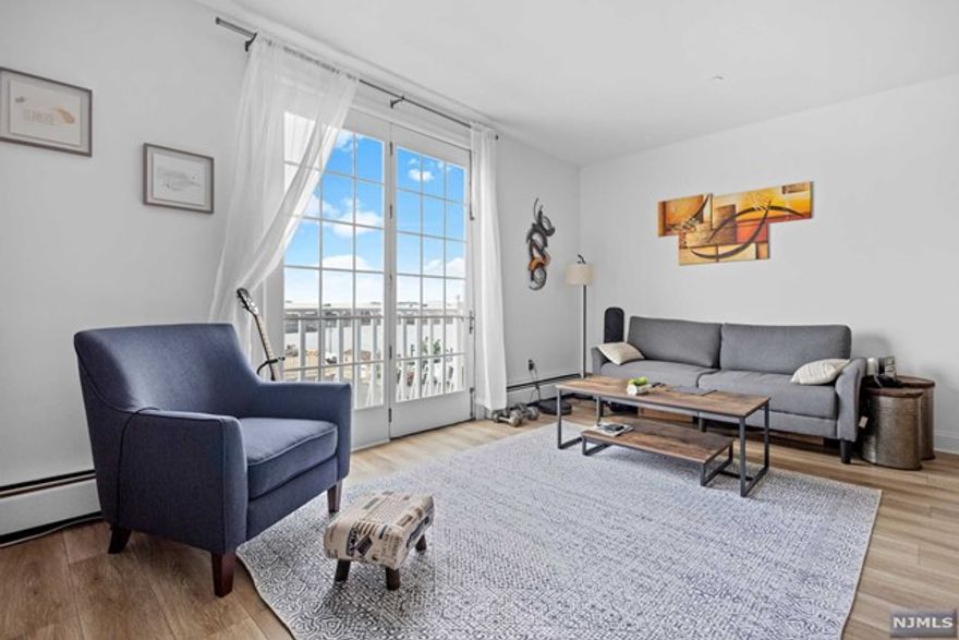 Welcome to Port Liberte! Southern exposure 1 bed/1.5 bath with abundant sunlight! Enjoy water views from both the bedroom and living room through French doors and Juliet Balconies. This unit features one of the larger one-bedroom layouts in the complex with 825 square feet. The kitchen seamlessly opens into the living/dining, perfect for engaging while cooking. The home boasts new hard surface flooring and all new stainless steel appliances. The generously sized bedroom includes a separate closet space leading to the primary bathroom. Laundry room is inside the unit for extra convenience. The monthly fee covers everything, including 1 covered parking space, heat, water, hot water, sewer, landscaping, snow removal, and access to the fantastic amenities of Port Liberte - 2 pools, gated community with 24/7 security, professional gym, sauna, club house, kids park, tennis & basketball courts. Unbeatable commute to the city by the Ferry across the street. A must see!