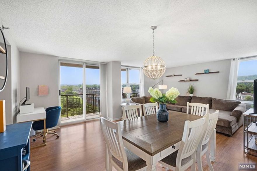 This corner unit offers an exceptional living experience with stunning views of the river, park-like grounds, and mountains from your private balcony! Located on the sunlit side of the building, this unit benefits from abundant natural light, enhancing its spacious open floor plan. With ample closet space (two walk-in closets) and in-unit laundry, convenience is prioritized. Parking is easy with an assigned garage space and plenty of visitor parking. The Mill offers a state of the art fitness center, a completely renovated community room, tennis courts, in-ground swimming pool, walking/jogging trails. A short walk away from local shops, restaurants and super easy NYC and Hoboken transportation via train or bus!