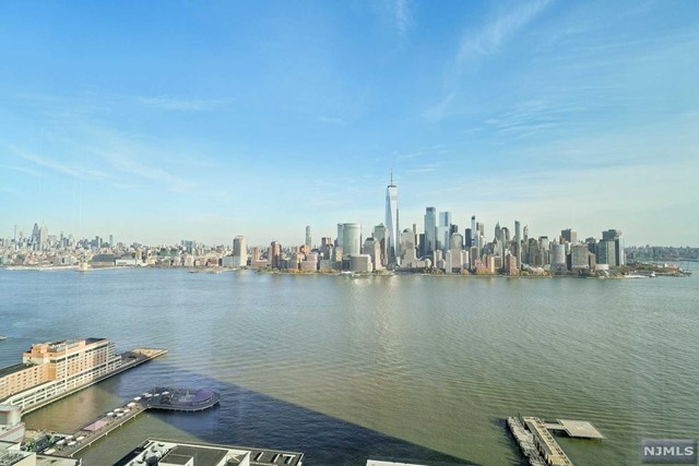 Pristine 1 BR w den with direct NYC views at 77 Hudson. This impressive east facing unit is 941 sqft on the 41st floor with an open floor plan exposing panoramic views of midtown & lower NYC. Stunning finishes include Italian cabinetry, modern European kitchen, bath & gleaming hardwood floors. An array of 5 star amenities include: 24hr fitness center, children's play area, jacuzzi, steam rm, private massage rm, game rm, virtual golf rm, screening rm, lounge, conference rm, Click cafe area, yoga & pilates rm, pool, BBQ area, fire pit & dog walking area. Grocery store & cafe on premises. Additional shopping, restaurants & schools nearby. LightRail, Path & Ferry across the street for quick commute anywhere. Parking not included but available for rent. Tenant pays electricity & heat. 1 month security deposit. Available 12/1.