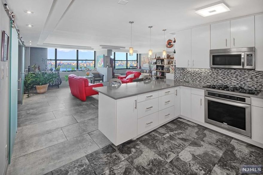 Absolutely stunning three bedroom, three bath condo at the sought after Galaxy Towers, full service luxury community. World class views from all rooms!! Open concept spacious floor plan with high quality design and current finishes. Dazzling ceramic, concrete-like flooring. Renovated kitchen with granite counters and stainless steel appliances. Custom lighting throughout. Formal designated dining area. Designer barn doors from living room to bedroom/sitting room. Master bath boasts high end tile, luxurious jacuzzi tub and chic vanity and lighting. Amenities include doorman, fitness center, indoor and outdoor pools, tennis courts, shops on premises. Steps to bus or jitney to NYC and shuttle to NY Waterway Ferry. Close to restaurants and shopping. The Epitome of Waterfront Living!!!