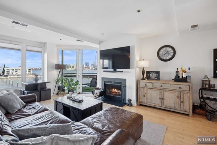 Luxury and convenience can be yours at this highly desirable one bedroom, one and half baths condo with unobstructed views of NYC and the Hudson River. Both the ensuite bathroom and half bath are beautifully renovated. The open kitchen has a beautiful view of the city with stainless steel appliances and an airy living room designed for hosting dinner parties topped off with a real wood burning fireplace for post-dinner entertaining. New Washer/dryer in unit, one garaged parking space included. Enjoy the best of both worlds with townhouse style private entrance to each unit, and condo amenities including state-of-the-art gym, indoor heated pool, and 24 hr concierge. The best location on the Waterfront features Whole Foods, NYC Ferry, Light Rail and Bus all at your doorstep.