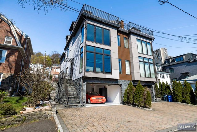 This seemingly modest duplex is a Contemporary masterpiece packed with many surprises: A South-East side that's flooded w/sunlight from sunrise to sunset. Nicely positioned with morning sun into the MBR, LR, & roof deck & evening light into the kitchen, DR, & front courtyard. Floor to ceiling glass throughout further enhances the natural light and serene surroundings. High end kitchen has Thermador appliances, Quartz counter tops, & + a large center island. Dramatic glass encased floating staircase is on a single beam. A "mid century" them throughout from wall covers & sconces to chandeliers & more. The MBR feels like a 5 star hotel room & has a spa like bathroom w/soaking tub that gets evening sunlight = great way to end the day. The lower level has an en-suite w/sep entrance w/rubber gym floor matting. The top floor is has it all: An incredible "lounge" room w/wet bar, 1/2 bath, that opens to a roof deck w/unobstructed views w/a tree top nature setting & NO HOA FEES!!