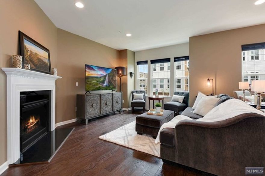 Situated perfectly in Wood Ridge's most sought after Townhome Community with ONSITE TRAIN STATION. A timeless colonial, PERFECTLY MAINTAINED & BARELY LIVED IN, is sophistically & practically designed, boasting 4BR/3.5BA-2,099 sqft. FEATURING-RARE 1st FLOOR MASTER BEDRM w/FULL BATHRM. This MANCHESTER layout impresses w/its OPEN CONCEPT LAYOUT, bringing together living-dining & kitchen spaces as one large gathering area. Large deck for recreation is a perfect EXTENSION to this floor! The kitchen offers granite countertops, pantry, KITCHEN-AID APPLIANCES, oversized island & abundant cabinets. Head upstairs to find a luxe primary bedrm w/Walk-In closet(CUSTOM SHELVING INCLUDED)& a SOAKING TUB in the BATH. Other features:NORTH-EAST FRONT ENTRANCE,2 Car garage+ 2car-drivway,storage closets,FIREPLACE,hardwood flrs, and FINE & TASTEFUL UPGRADES THROUGHOUT. Steps away from NJ Transit train & bus, schools, dog run, kids park, ON-SITE WINE/COFEE SHOP. Close to all major highways.