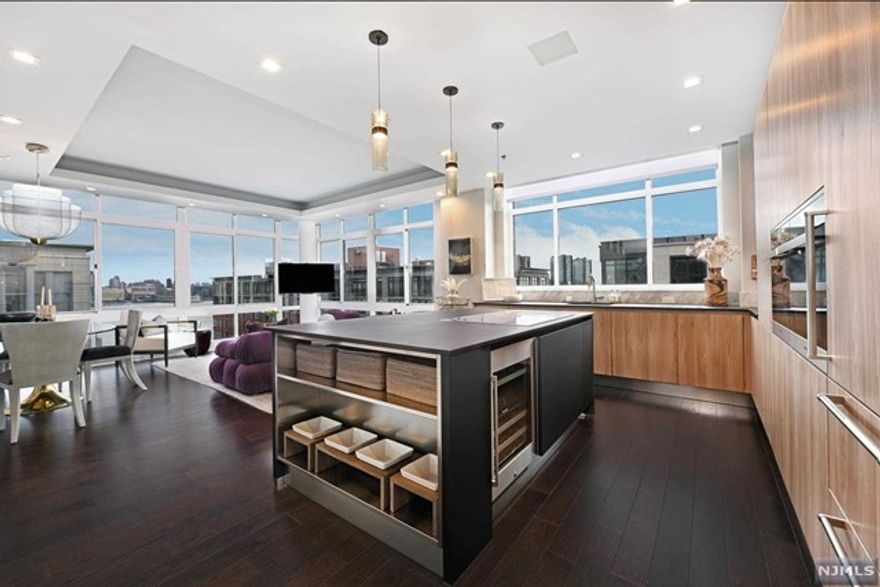 Stunning SE facing 2 bedroom 2 bath corner Penthouse with NYC views in the luxury waterfront Maxwell Complex. This spectacularly customized and upgraded home strikes an inviting balance of warmth and comfort in a modern aesthetic and was featured in Design NJ, highlighting its beautiful and sophisticated kitchen redesign overseen by Mimi&Hill of Westfield. Appointed with Arclinea cabinets, Dekton countertops, Carrera marble backsplash, Miele appliances including induction cooktop, downdraft exhaust, 2 wall ovens- conventional/convection and convection/steam, SubZero refrigerator and Gaggenau dual zone wine cooler, this fabulous kitchen is as chic as it is chef worthy. Raised ceiling heights in the kitchen and the living room, with tray ceiling and custom cove lighting, add to the open loft-like feel with a bespoke built-in dining banquette with Moooi chandelier enhancing this exceptional space. An en suite oversized primary bedroom has soundproofing to ensure peaceful rest.