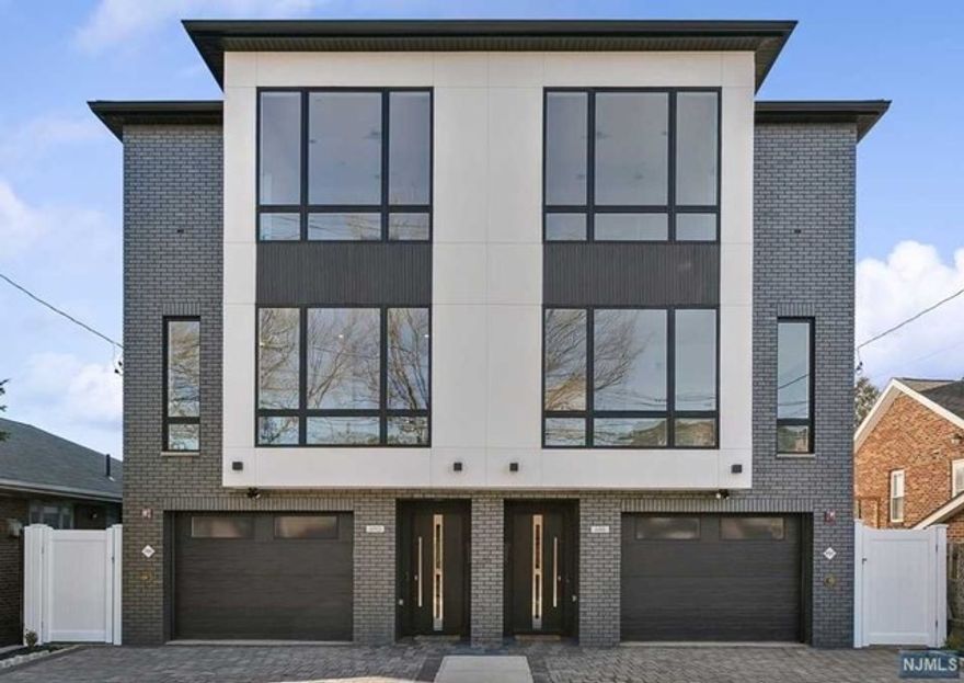 Luxurious modern design townhome nestled in Cliffside Park's most desirable neighborhood and with incredible views of NYC. 4-story living space includes a roof terrace with a wet bar, sleek design, and carefully selected modern and top-of-the-line fixtures. The first floor boasts an open-plan modern kitchen with a quartz waterfall countertop, premium smart appliances, a powder room, and a bonus office/family room. It features 3 large bedrooms, 5 baths, a large recreation room on the ground floor, an office/family room on the first floor, a roof deck with a wet bar, and a mudroom on the ground floor. The house has a fire sprinkler system, 4 zones AC and heat, a Fireplace, sleek LED lighting, a hardwood floor, tons of storage, abundant natural light, a large attached garage, and a genuine 2-car driveway. It is close to restaurants, shops, supermarkets and only ONE minute's walk away from express NYC buses.