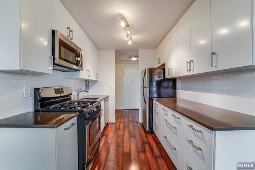 HALF FEE PAID - Experience unobstructed sunset views from this modern, recently renovated 950 sq. ft. penthouse unit located in an elevator building on prestigious Boulevard East. The large living room and dining area offer flexible use, while the extra-large bedroom features a wall of closets for ample storage. The modern kitchen is equipped with stainless steel appliances, and ceiling fans and wall A/C units are installed in every room for comfort. Additional storage is available throughout the unit. On-premises laundry facilities and 24/7 on-site super services add convenience. Enjoy a quick 20-minute commute to NYC with transportation available right at your doorstep. Reserved parking is generally available for an additional fee, subject to application approval by the management company. This prime location is close to shopping, restaurants, coffee shops, and parks offering free tennis and pickleball courts.