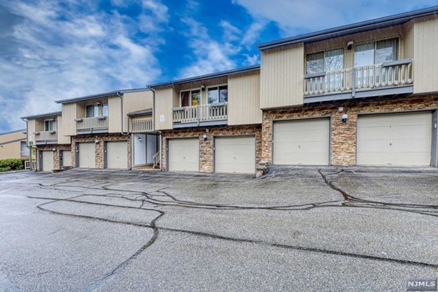 Desirable Scenic Hill Villas, this is a second floor one floor unit with 2 bedrooms and 2 bathrooms. Enter the over 1300 sq ft unit with a spacious living room with gas fireplace, recessed lighting, spot lights for the fireplace and gleaming newer hardwood floors installed 5 yrs ago. Behind the fireplace is a den/office space with many windows for rays of sunlight. Living room is open to the dining area with a large deck overlooking a scenic walking path with gazebo. The kitchen has a breakfast bar, pantry closet, lots of cabinet and stone countertops, stainless steel appliances. Stackable laundry closet too. The first bedroom has door to the second bathroom, sliding doors to a balcony and closet. The bathroom has a stand up tiled shower. The primary bedroom has high ceilings, walk in closet, over 90 sq ft attic for storage, primary bathroom with shower over tub and sliding doors to a second balcony and a second closet. Lots of community amenities and NYC transportation.