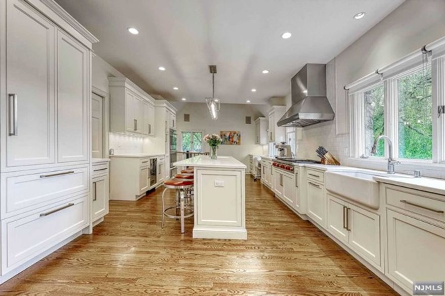 Comfortable Tudor-style home with over 6,600 square feet of living space. The two-story foyer opens to a grand staircase, living room with marble fireplace, and formal dining room perfect for entertaining. Outstanding gourmet Kuche+Cucina modern eat-in kitchen with professional grade appliances, two Subzero refrigerators, two Wolf ovens, two sinks, and breakfast nook. Great room with fireplace, French doors to yard, and wall of windows overlooking pool. First floor bedroom, full bathroom, solarium, and powder room. Second floor master en-suite bedroom with fireplace, vaulted ceiling, full bathroom with marble bath, and custom walk-in closets. Two full en-suite bedrooms each with its own full bathroom complete the second floor. Private backyard with salt water in-ground swimming pool easily accessible from patio and walk-out fully finished basement with bedroom currently used as den and full bath, gym, summer kitchen, and rec room with billiards table.