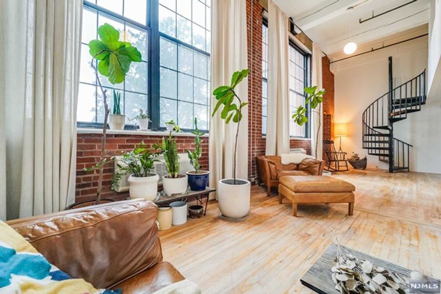 Rare and beautiful SoHo-style loft only 20 minutes to the GWB/NYC. Enjoy the expansive openness and natural light of the main living area with its exceptionally tall ceiling, massive windows, and exposed brick and timber beams. Separate from this area are a remodeled bathroom with walk-in shower and large kitchen with a high ceiling and window. The upstairs offers two lovely sleeping loft spaces. A gym and grocery store are in walking distance. The building offers 1 parking lot space, on-site laundry, and an elevator. Recent improvements include: all lighting replaced with dimmable LED fixtures, all doors and hardware replaced using concealed hinges, AC units replaced, water heater replaced, solid white oak flooring throughout, all trim redone with minimalist flush reveals, and all new tile in the bathroom.