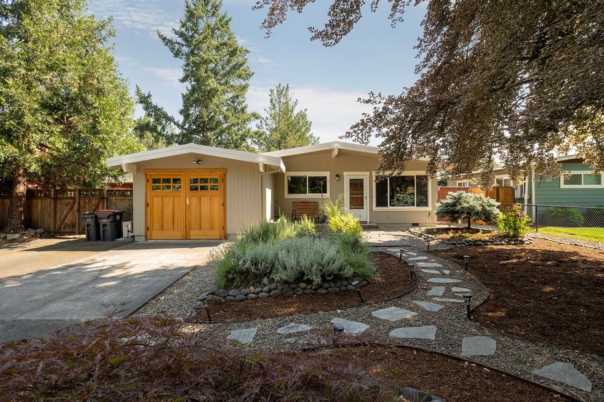 Attention first time home buyers or those wanting to downsize!  This 3 bedroom, 1 1/2 bath home, built in 1960, features living room with vaulted ceiling, hardwood floors, wood burning fireplace with brick surround, kitchen with laminate flooring and counters with a mosaic slate backsplash, electric range/oven (stubbed out for gas as well), built in microwave, and stainless refrigerator.  All three bedrooms have laminate flooring, hall bath with vinyl flooring and a tub/shower combination with tile surround.  The one car garage is currently used as a ''flex'' room that is insulated, and has laminate flooring and a mini split for heating/cooling.  Backyard has a 20x16 covered paver area for entertaining, artificial turf w/putting green, chicken coop and greenhouse.  Updates include freshly painted exterior, fencing, interior doors, vinyl windows, furnace and metal roof. Tucked away in an established neighborhood that is convenient to schools and shopping.  ...Welcome Home!