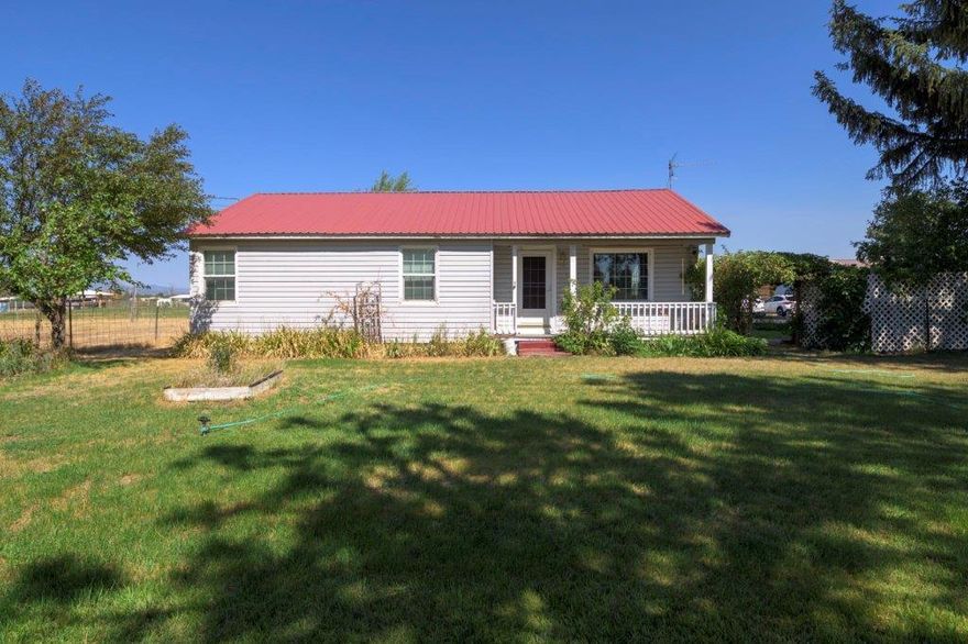 This small acreage with its 3 bedrooms 1.5 bath home needs some updating, love and TLC. The setting has mature trees and a bridge over the irrigation ditch where you will find pasture land that is fenced and cross fenced and an old barn. There is a separate shop and the double garage is extra large. The home has a large family room that could be a formal dining area, a nice living room and decent sized bedrooms. There is a big mud room with a 1/2 bath off the back porch and a covered breezeway connecting the house to the garage. The backyard is fenced & private and the driveway is gated. The property has great potential and is just waiting for your vision. 3 party well. Located near shopping and medical facilities.