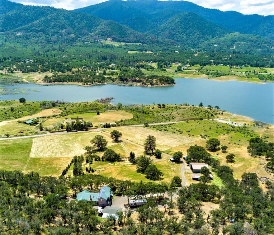 Unobstructed views of Emigrant Lake from this custom home on 16.31 ac. of Ashland farm land. Easy access to the lake for all your water activities. Enjoy country living with the luxury of Ashland amenities. The home was blt to take in the lake views from the living room & kitchen. Vaulted living rm w/ cozy wood stove. Kitchen has a spacious island for entertaining. The main level primary suite includes separate office, double vanity, glass block shower enclosure & a walk-in closet. Venture out onto the deck to take in the stunning lake & mountain views. High end 2009 Triple Wide MH sits below, used as a Hardship Residence, with own deck and lake views. Pastures for horses & four-stall barn w/ tack room, fenced and cross-fenced. Room to store your RV. For energy efficiency there's a 26-panel solar array grid-tied system. Plenty of garden space for the green thumb w/ already established table grapes & fruit trees. Lake recedes in late summer but still remains a beautiful setting.