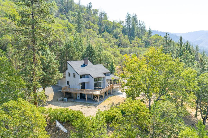 1st time on the market! Custom home built by Baldwin homes w/soaring ceilings, lg windows, many sliders to outdoor patios & decks, wood burning fireplace, 2 car portico. Many new updates includes new roof, beautiful new wide plank laminate flooring, new carpet, new wall oven, 2nd convectional wall/microwave oven, new refrigerator, dishwasher & wine refrigerator, granite counters w/eating bar, new exterior paint on cedar siding, new interior paint, newer heat pump w/back up wood forced furnace very efficient! Tile floors in all 3 bathrooms. Lower level Primary suite w/sitting area, lg shower, wood-burning fireplace & slider to a large patio. Main level living rm, kitchen, formal dining rm/office w/wet bar, great sunroom w/tile floors & many windows to take in the views. 3 bdrms upstairs 2 w/vaulted ceilings w/loft & balcony. Separate lg insulated shop room & separate insulated studio + an oversized 2 car garage, 3 carports & woodshed. Home sits on top of the mountain w/beautiful views.