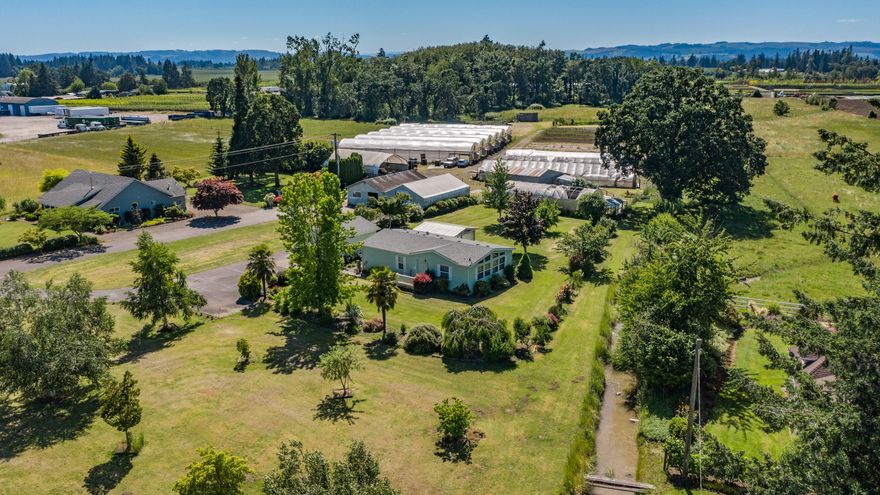 So many potential agricultural income streams with this outstanding property.  The sky is the limit with one newer house, a hardship home, almost half an acre under the 6 bay Nexus gutter connect greenhouse and several other useful outbuildings to support your business and/or habits. 80 gpm irrigation well, Amity soils, plenty of garden space and room for your animals. The updated main house is a roomy quiet retreat from your busy day w/ a huge great room, large covered porch and inviting back yard.