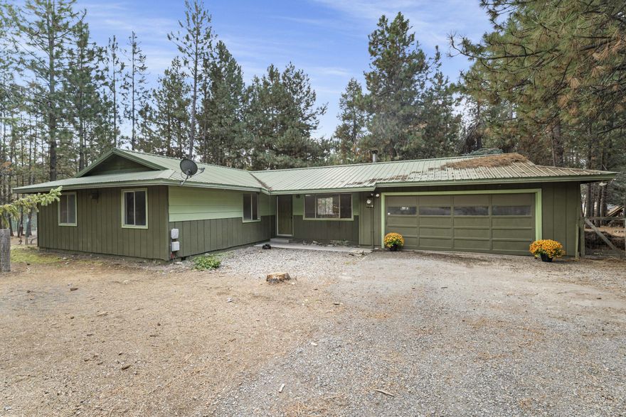 Set on nearly an acre of level land and surrounded by mature pines, this property offers space to breathe, play, and create your own outdoor retreat. With plenty of amenities already in place—including a pull-through driveway, shop/barn with covered RV storage, fenced yard, wood shed, and fire pit—you'll have the perfect foundation for living your best outdoor life. Inside, a certified wood stove, oversized garage with built-in storage and workbench, and flexible living spaces give you room to add your personal touch and earn instant equity. Whether you're looking for your first home, an investment, or a retirement retreat, this is an opportunity to enjoy Central Oregon's outdoor mecca right from your doorstep. Seller is highly motivated—don't miss your chance to make this property shine with your vision.