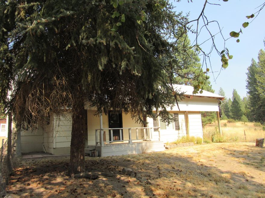 Small but very livable, a single wide with an addition on 4.11 acres. 1 bedroom could be 2  has a metal roof over all of it. Has a couple of fenced areas for a horse and a  barn . A couple of storage buildings. On well and septic.