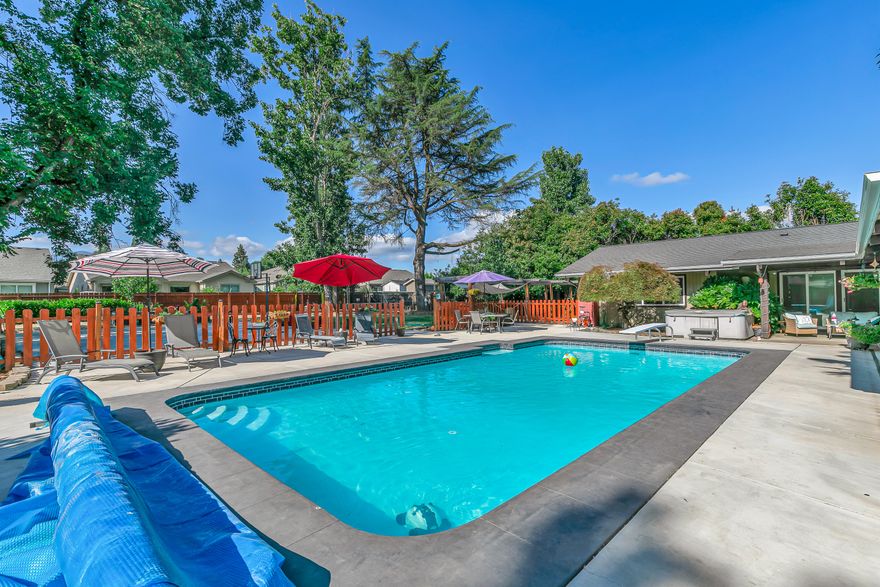 Entertainers dream home in a prime location! Single-level 4 bedroom, 3 full-bath custom-built home on a huge .53 acre private lot with a large remodeled inground swimming pool (18x38x10), basketball court, lawn, mature trees, & fully fenced yard. Surrounded by 8 sliding glass doors, the pool & patio area create seamless indoor-outdoor living. Vaulted open beam ceilings with rough-sawn cedar, clear stained cedar siding, skylights, 3 fireplaces, & so much more. Loaded with upgrades: newer 40-year R35 architectural roof, newer HVAC, tankless water heater, vinyl plank & hardwood floors, newer windows & doors, granite counters, butler's pantry with wine fridge, & gas oven. Oversized garage with EV charger, workshop, built-ins, & pool equipment room. Huge primary suite with gas fireplace, 3 more spacious bedrooms, Jack & Jill layout, amazing large rec room, & tons of storage throughout. Massive covered patio, poolside bath, & unbeatable privacy. An absolute must tour!