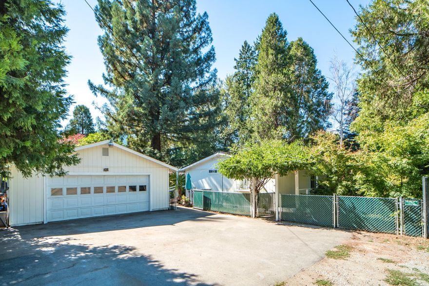 Charming Creekside! Discover peace and privacy in this well-kept, spacious home nestled on just under half an acre. Featuring 3 bedrooms & 1.5 bathrooms, this home boasts an open floor plan and a sun-filled bonus room making a very special primary suite. Vaulted ceilings, skylights, hardwood oak flooring and Quartz counter tops in the kitchen. Enjoy covered decks on both sides, opening to lush grounds. Meandering pathways lead through the spacious yard—ideal for projects, gardening and play—down to serene creek frontage, offering the perfect spot for picnics, relaxation, or simply enjoying nature. A detached 2-car garage provides ample storage with a large, paved area for additional parking. Located in the quaint Rogue River, this home offers convenient services & access while still embracing a tranquil, easy-living lifestyle.