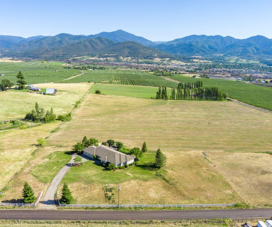 One of a kind East Medford exceptional single level home w/lg windows to take in the views of the city lights, vineyards, orchards & Cascade mountains. 21.14 acres would make a great vineyard or horse property w/mini hay barn. 17 acres of TID irrigation rights zoned EFU. Open kitchen to family rm & breakfast rm w/bay window. Granite counters w/ island, granite counters in kitchen w/ dbl ovens, butler pantry. Built in book cases & wood burning brick fireplace in family rm. French door to a lg deck w/ arbor & grape vines, garden, raised beds, 3 car finished garage, tile roof, some vinyl fencing. 2 master suites, 1 with walk in closets, dbl sinks, lg shower & jetted tub. Formal dining rm & living rm. Hardwood floors in main part of the house & nice carpet in bedrooms. 9' ceilings through out. Lg laundry rm or hobby room. Ashland school district. Great rural property close to Medford & Ashland.