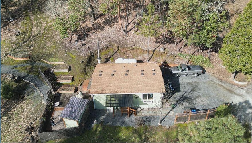 This fabulous home has been completely refurbished inside..  The outside has new siding, inside has new flooring, paint, cabinets redone, closets redone, and much more.  The home has 2 bedrooms, one is currently used as a sitting room. The washer and dryer are included. The hot tub and the patio furniture on the deck are also included. 
There is also a she shed.  RV hookups. Nearly four acres of wooded property.  The Applegate River is across the road. Backs to BLM.