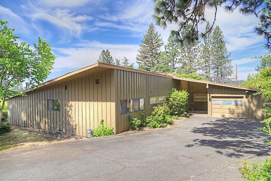 City Lights!! This Mid century modern classic has an expansive panoramic view of the Grants Pass Valley. You can enjoy this view from the full length windows throughout the house, or hanging out on the patio. Both day and night the views are amazing. This house is located in a desired NW neighborhood of the city, but has a private feel with it's large .51 of an acre. It features 3 bedrooms, 2 full baths and 2112 sq.ft. with a quaint eat in kitchen, a formal dining area, plus a large family room that would make a great game room or man cave. There is plenty of storage with all of the classic 1950 built-ins as well as a large basement. Outside you will find mature fruit trees and a great area for a garden,a pool, or anything else you might enjoy. Don't miss the opportunity to make this classic your own. Call for your appointment today.