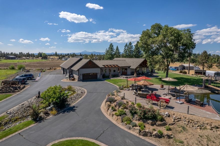 Now priced below a recent appraisal. Mtn views, located minutes from the hospital and shopping on the East side. Plan on spending enough time to enjoy all it has to offer. Situated well back off the road, with a paved driveway, you'll notice the beautiful home and the beach-like atmosphere of the spacious deck overlooking the concrete/lined pond with waterfall and suspension bridge. You'll enjoy entertaining friends and family or just sitting and enjoying the scene. Inside the home, you'll enjoy the stunning Cherry flooring with a matte finish that feels very inviting.  The vaulted ceiling is finished with a clear, light and bright wood that brings the outside light in. The Kitchen is spacious with a cook island, plenty of cabinetry and a breakfast nook area. The property has 3 acres of COID irrigation available.  A Koi pond, dedicated gym, large 4 car garage space, RV parking w/power, set up for horses or 4H animals. Watch the Pilot Butte 4th of July fireworks from the back deck.